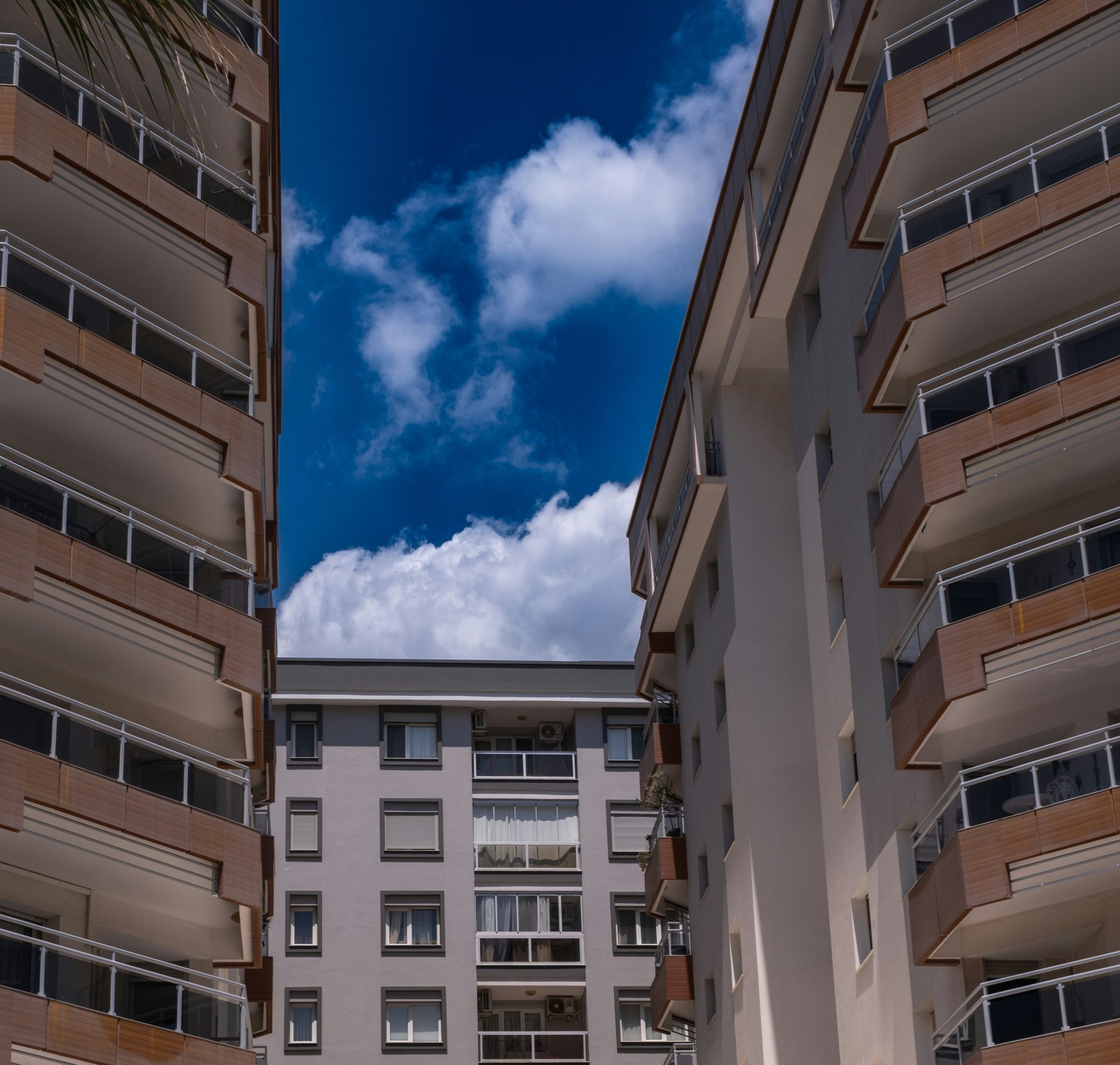 Apartment buildings with balconies under a bright blue sky