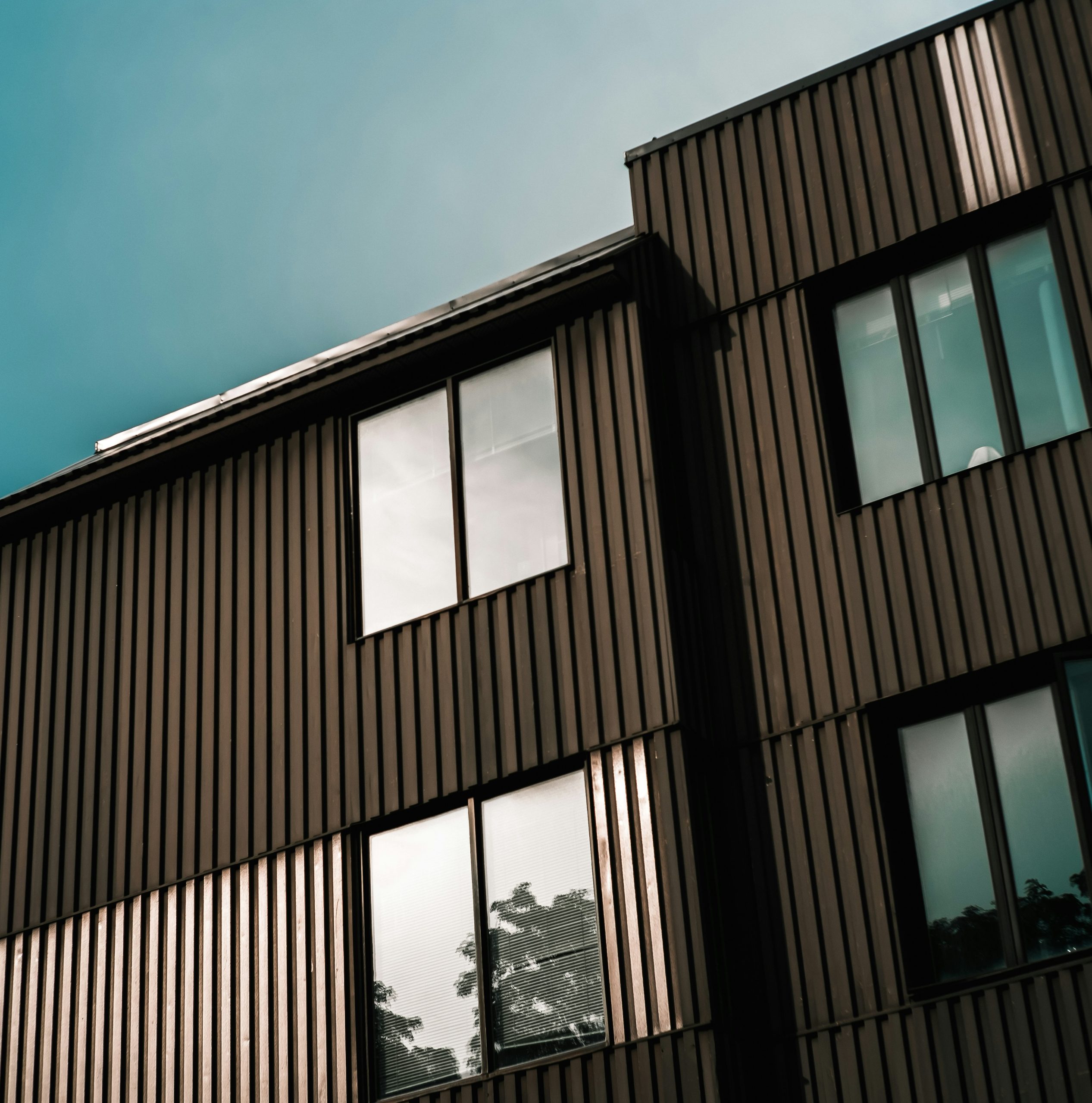 Modern building with dark vertical timber cladding and large windows