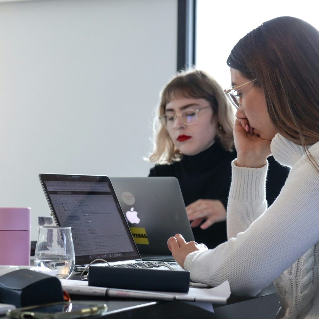 Two women working on laptops during a focused business meeting