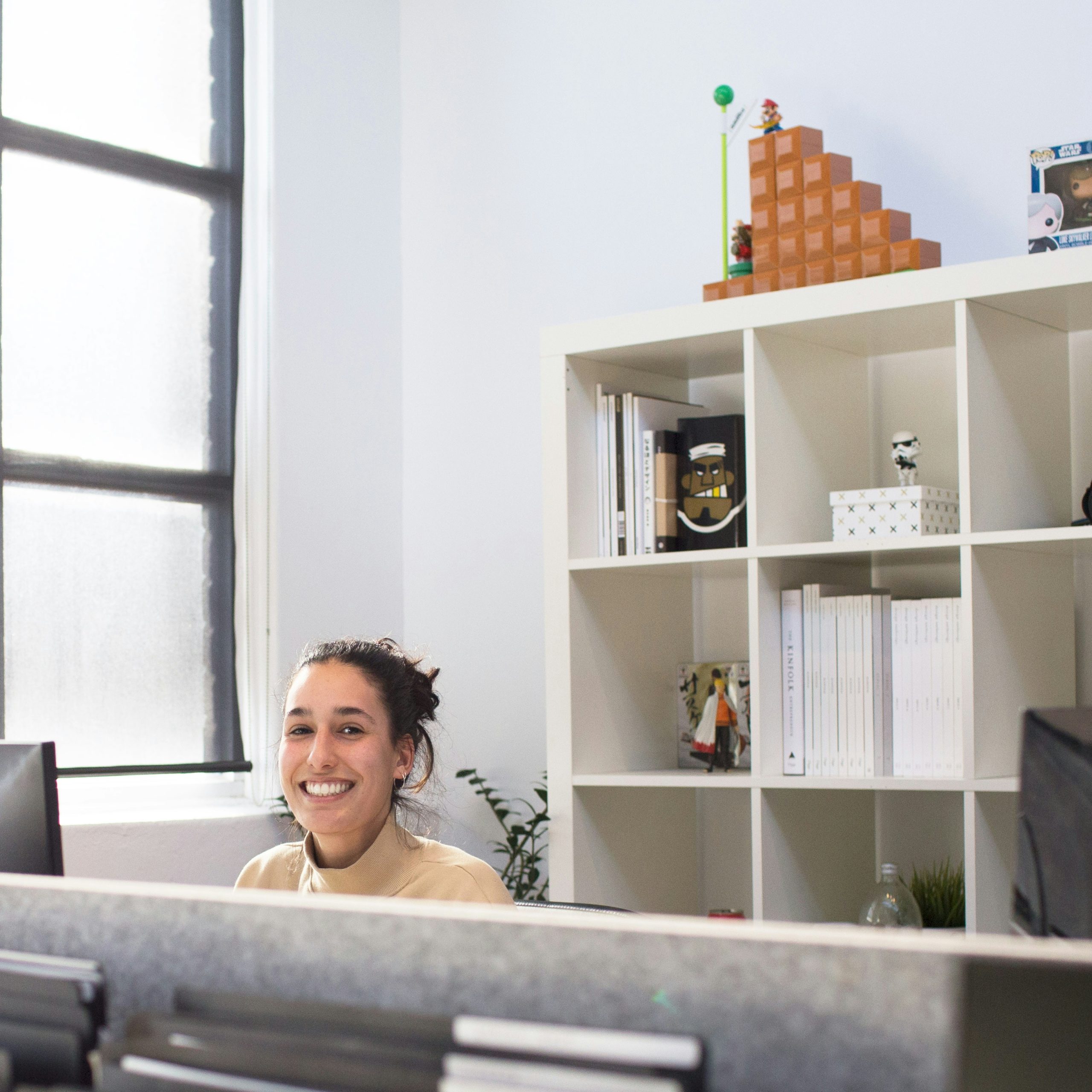 Smiling woman at her desk in a bright, modern office