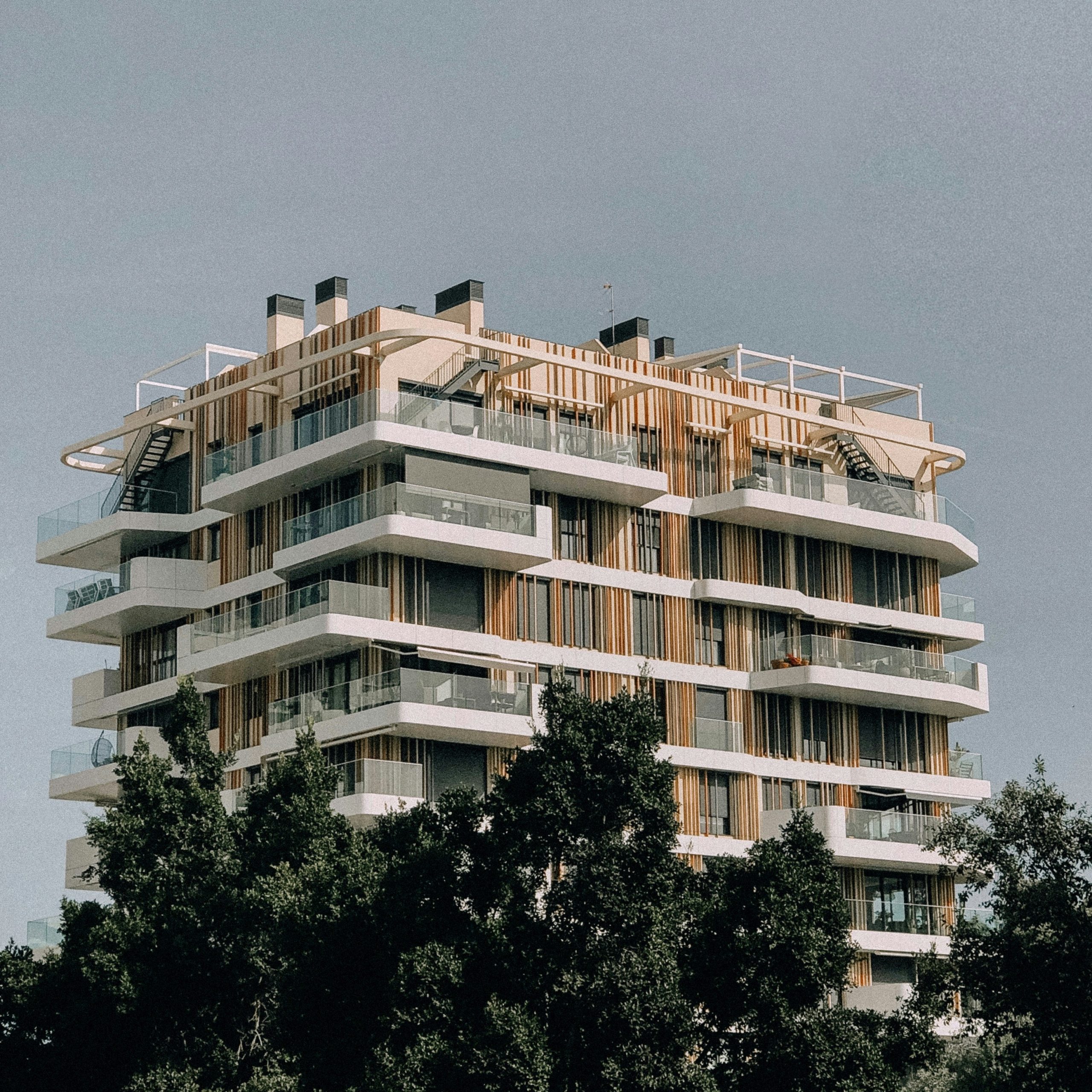 Apartment buildings with balconies under a bright blue sky