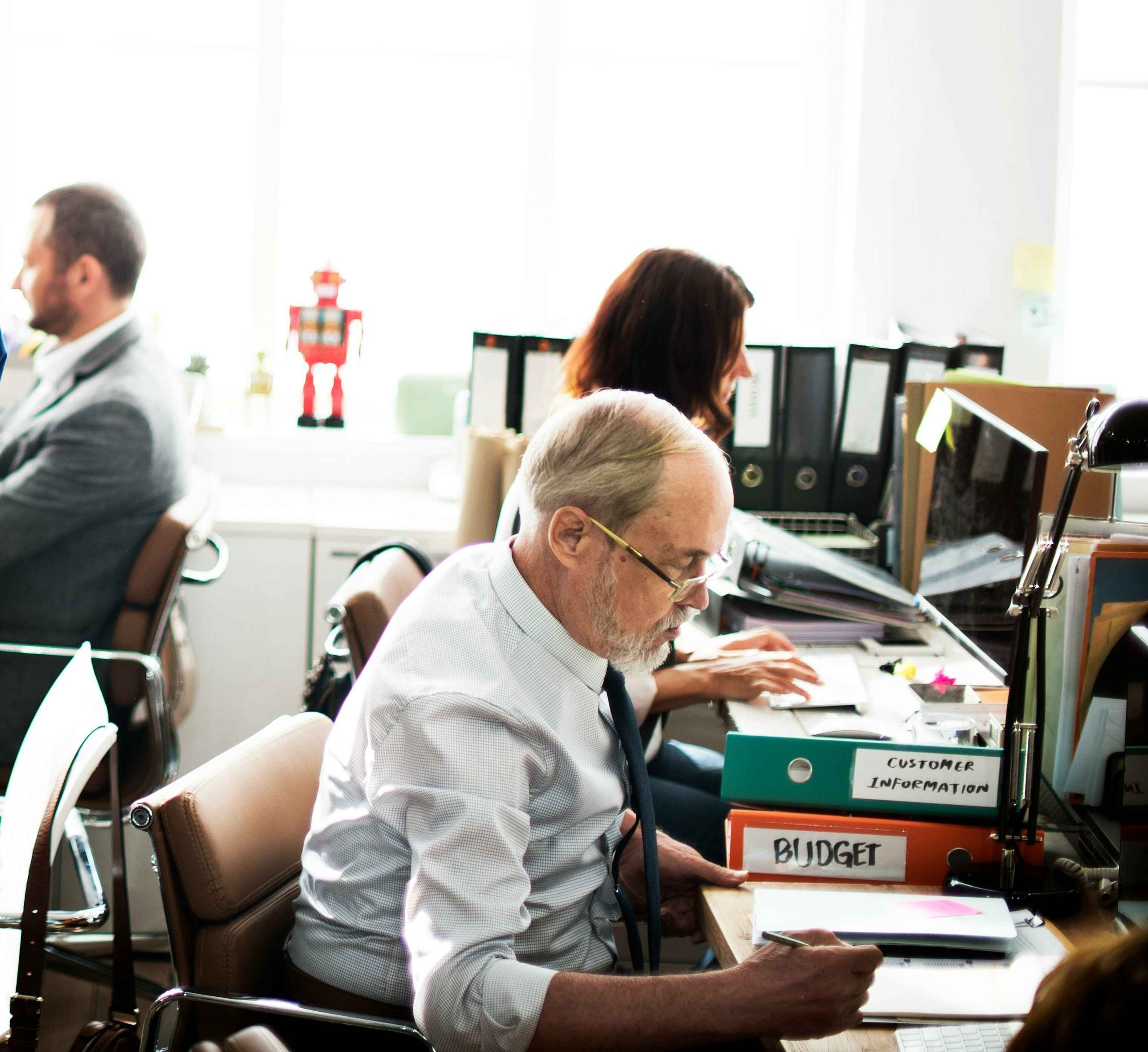 Business team working in a busy office with budget files and binders