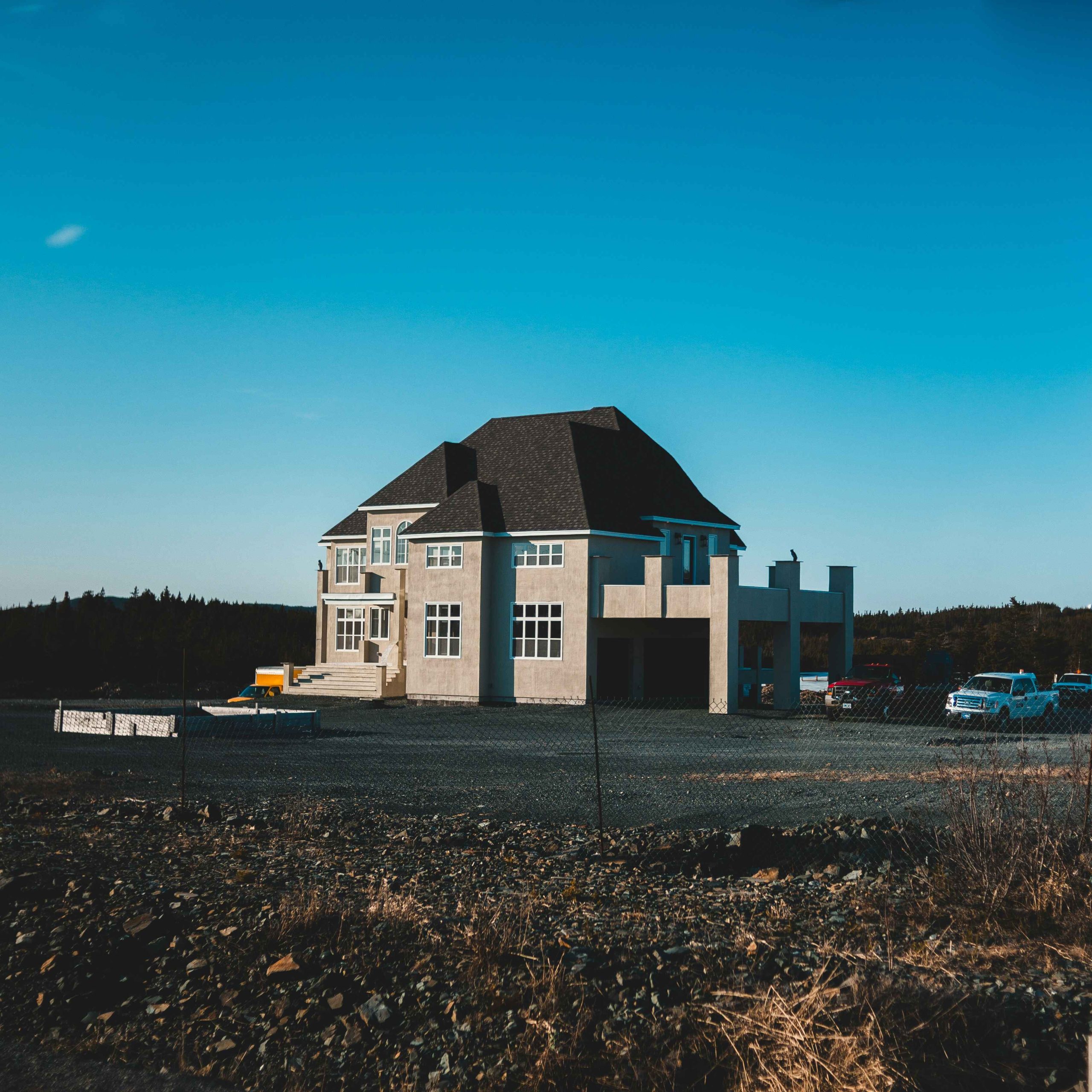 Newly built two-storey home on a cleared block under blue sky