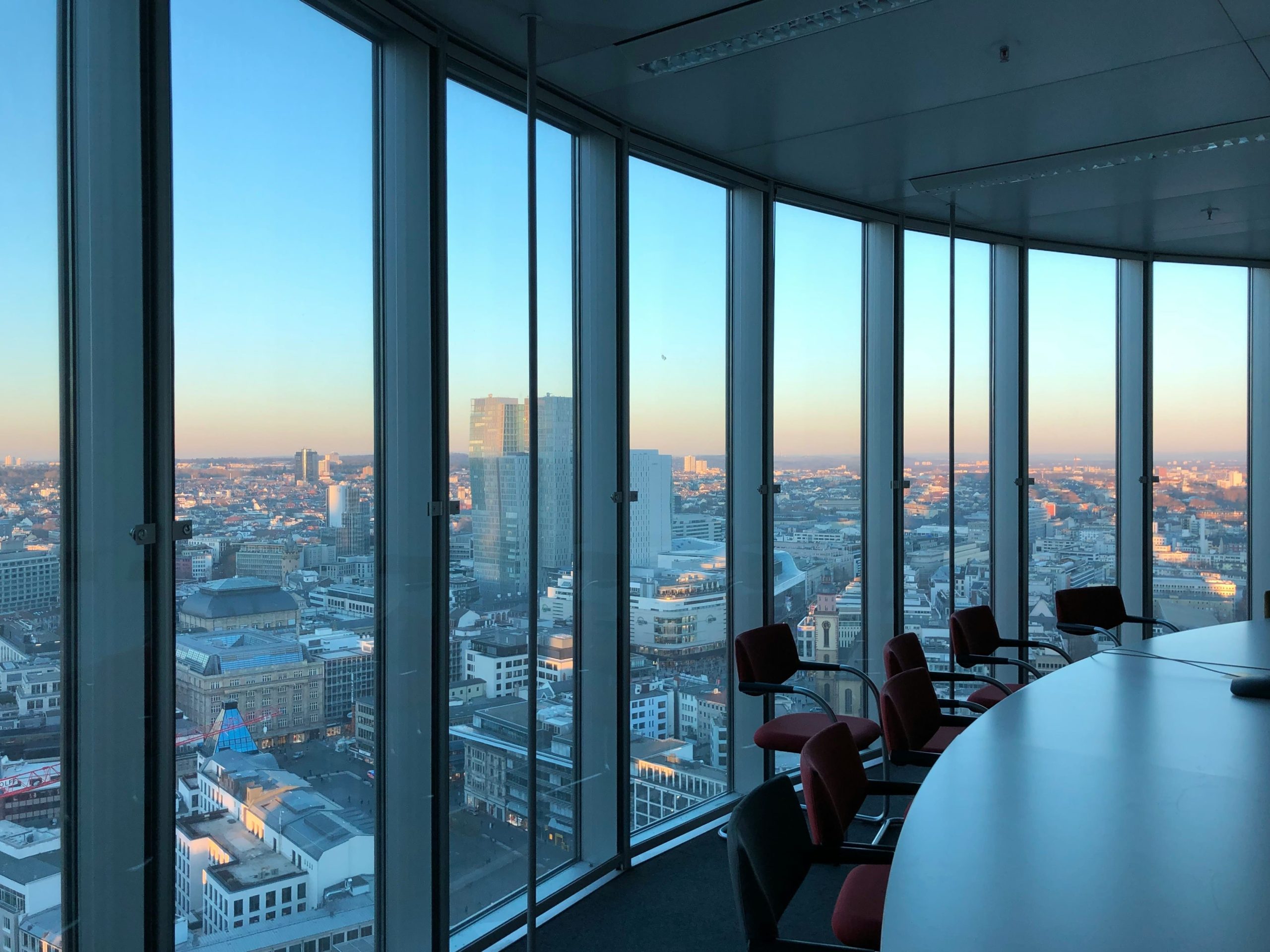 Modern conference room with panoramic city skyline view at sunset