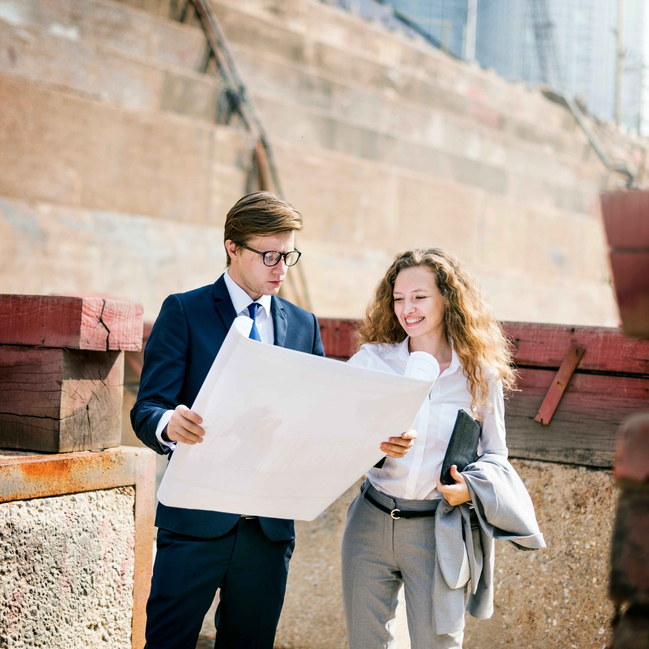 Two professionals reviewing building plans on a construction site
