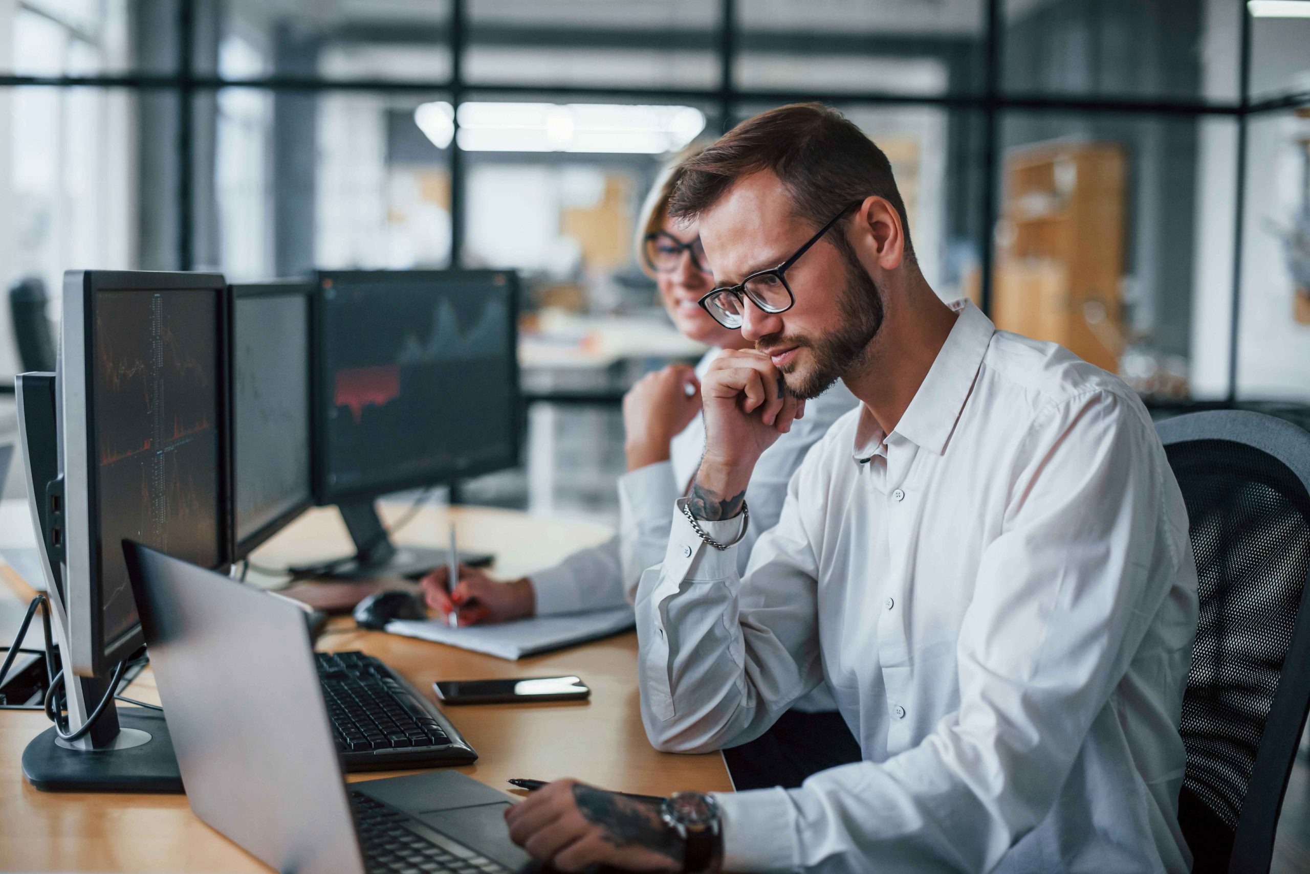 Financial analysts reviewing market charts on multiple computer screens