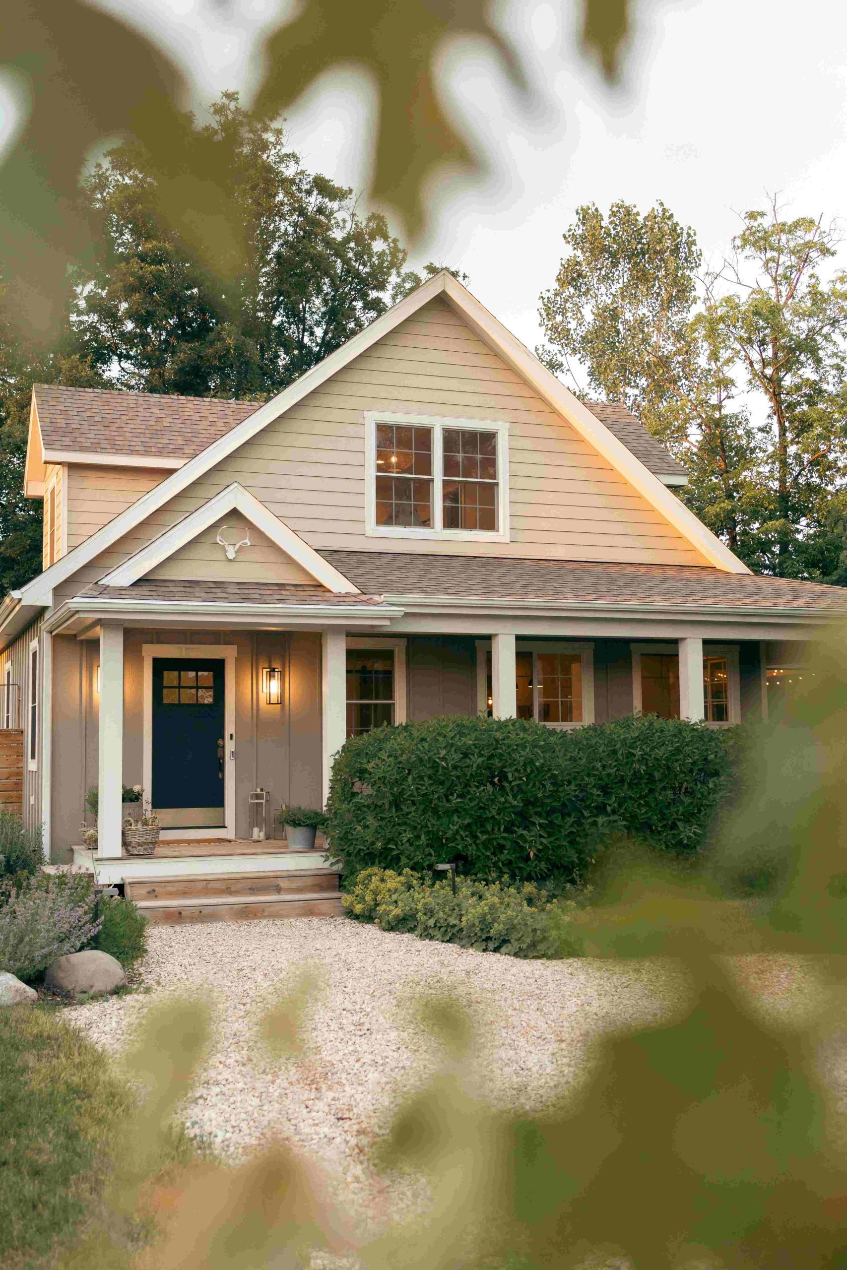 Cosy family home with a navy front door and covered porch at dusk